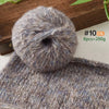 A ball of gray and blue soft alpaca blend yarn for knitting and crochet, shown next to a knitted item.