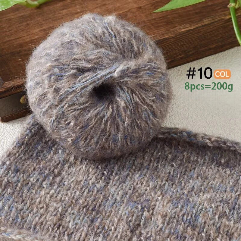 A ball of gray and blue soft alpaca blend yarn for knitting and crochet, shown next to a knitted item.