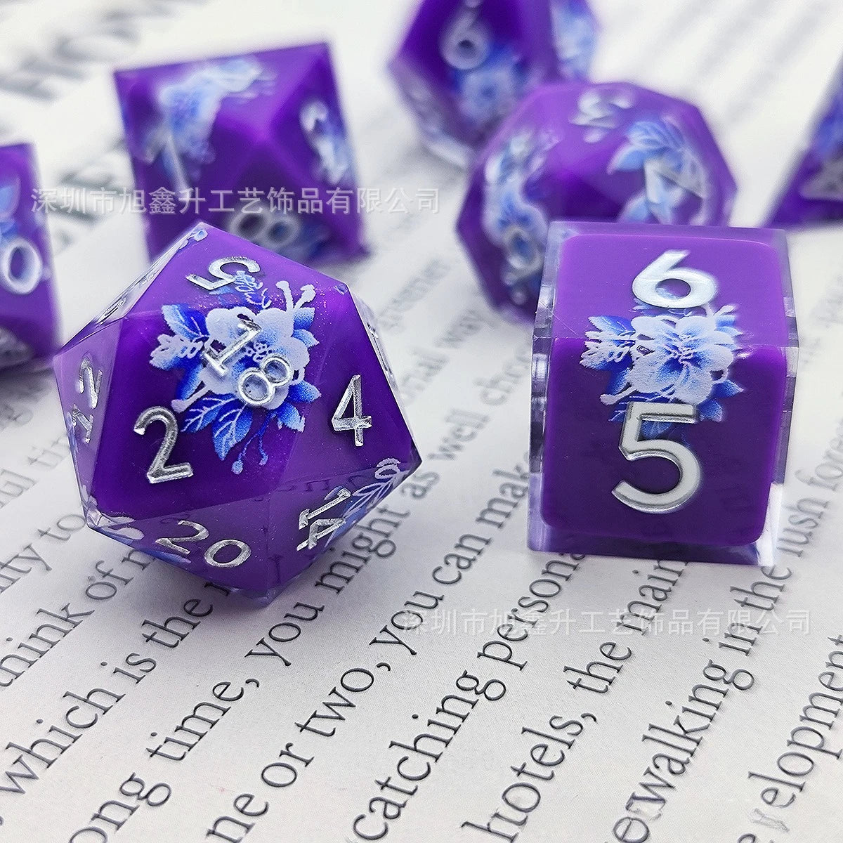 A purple resin die showing the number 6 with a blue floral design, placed on a white background.