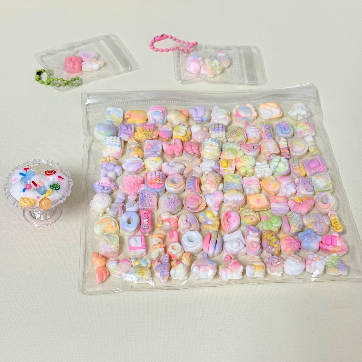 A clear plastic bag filled with numerous colorful kawaii cat paw squishy stress relief fidget toys and some loose pieces.
