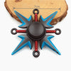 A metal fidget spinner with a rainbow finish, featuring black and blue blades and red accents.