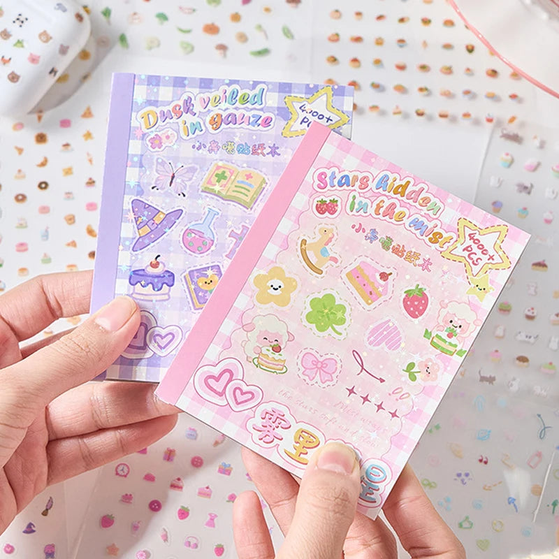 A hand holds a pink and purple die-cut sticker book featuring stars, a duck, and other cute cartoon designs.