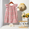 A pink floral smocked summer dress for girls with flying sleeves displayed on a hanger.