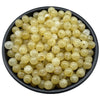 A pile of translucent yellow and clear acrylic round beads for jewelry making.