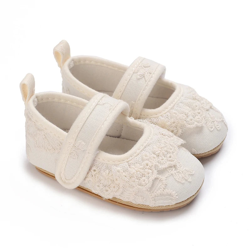 Pair of cream lace-trimmed baby girl moccasin shoes with bows