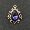 Gold plated water droplet charm featuring a deep blue crystal rhinestone set in an ornate flower design.