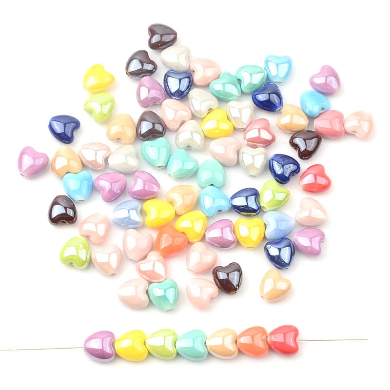A collection of multicolored heart-shaped acrylic beads in various shades of pink, green, blue, and yellow.