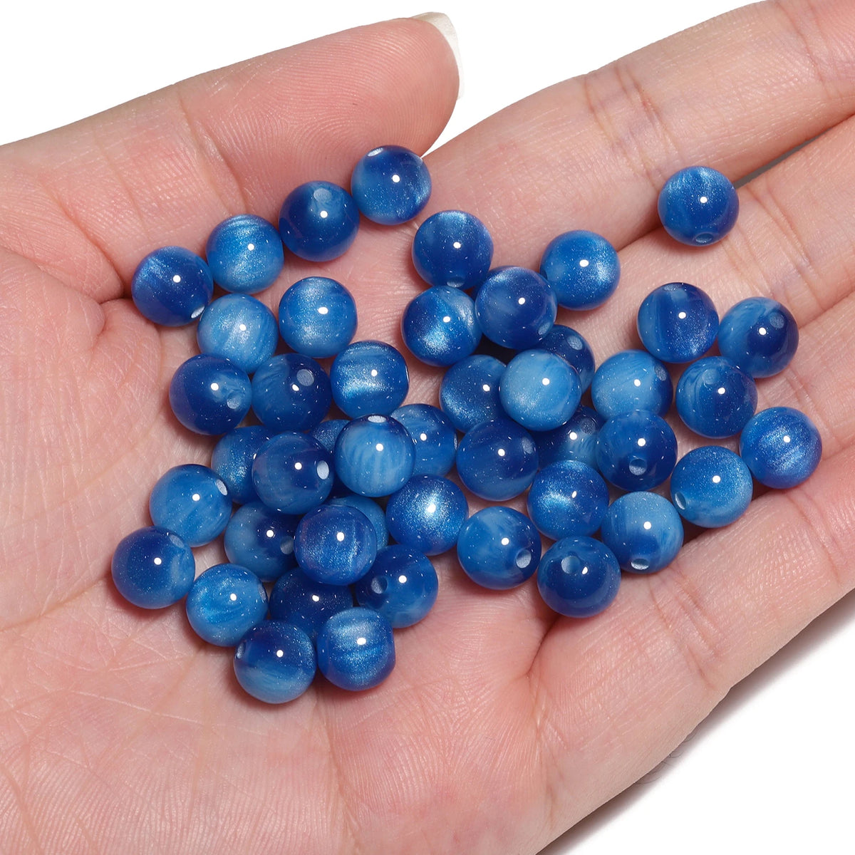 A handful of vibrant blue tiger eye resin beads for jewelry making