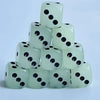 A stack of ten glow-in-the-dark dice in a pale green color, showing black dots.