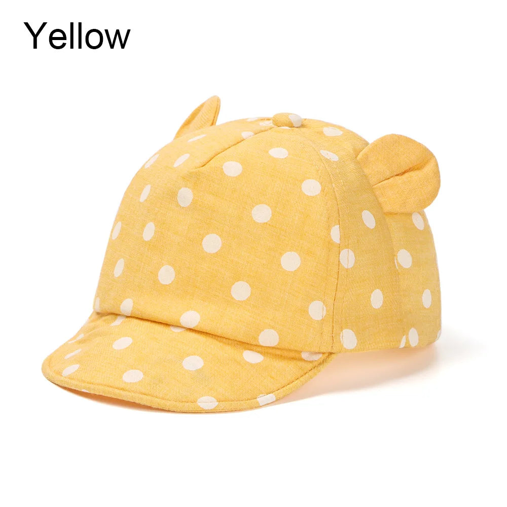A yellow baby cotton baseball cap featuring cute rabbit ears and white polka dots.