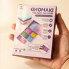 A box of a modular diamond painting organizer with 38 slots and dot pens is held in a hand.