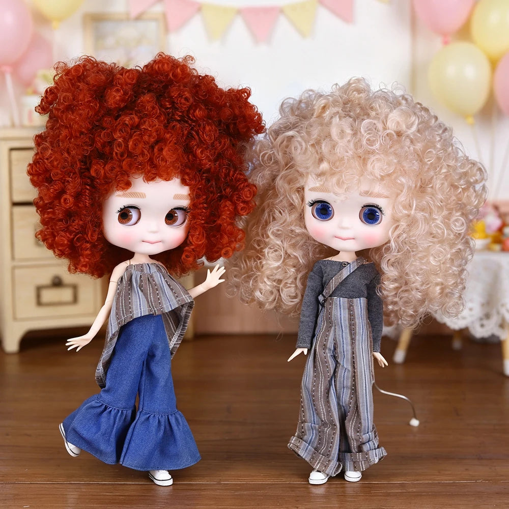 A pair of Blyth 1/6 scale fashion dolls with curly hair and cute faces standing on a wooden floor.