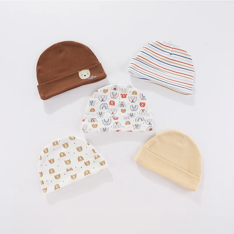 A collection of five knitted baby hats featuring various cartoon designs and stripes in brown, white, and beige.