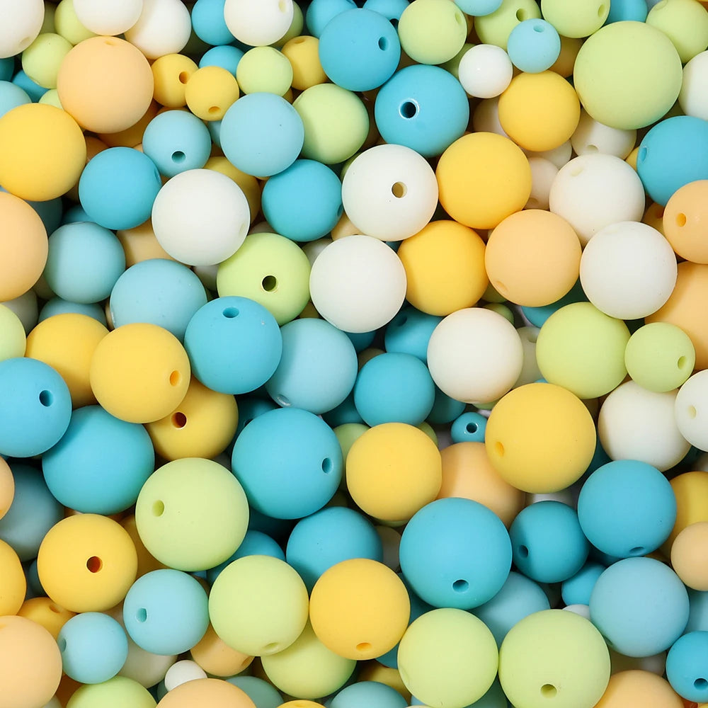 A close-up view of a variety of matte acrylic beads in pastel colors including yellow, blue, green, and white.