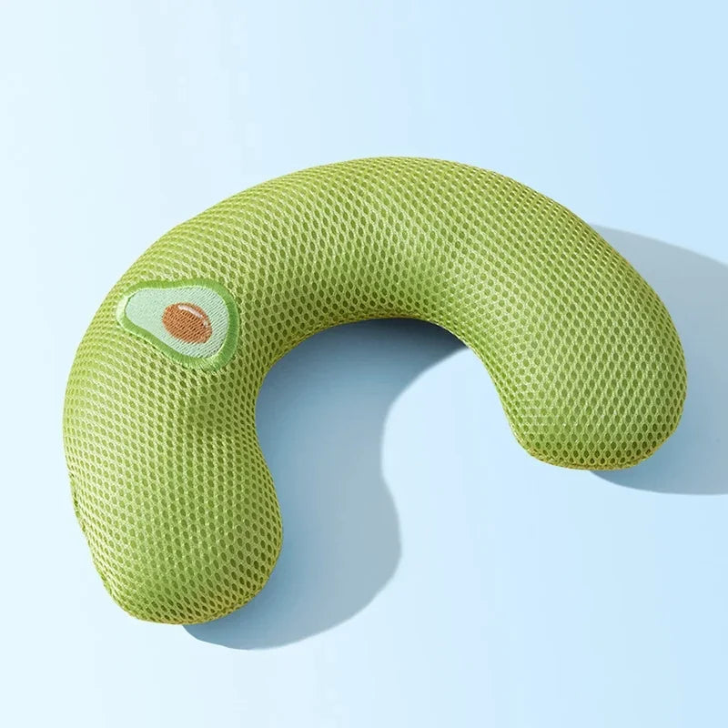 A light green, U-shaped plush pillow designed for neck support, featuring a small, oval-shaped accent.