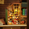 A wooden miniature dollhouse kit with an open door displaying various small decorative items and a yellow ladder.