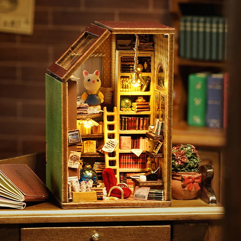 A wooden miniature dollhouse kit with an open door displaying various small decorative items and a yellow ladder.