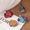 A set of enamel pins featuring dragon dice designs in various colors and shapes on a brown textured background.