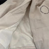 Close-up of a cream-colored kids' hooded letter print zip-up jacket showing the zipper and fabric detail.