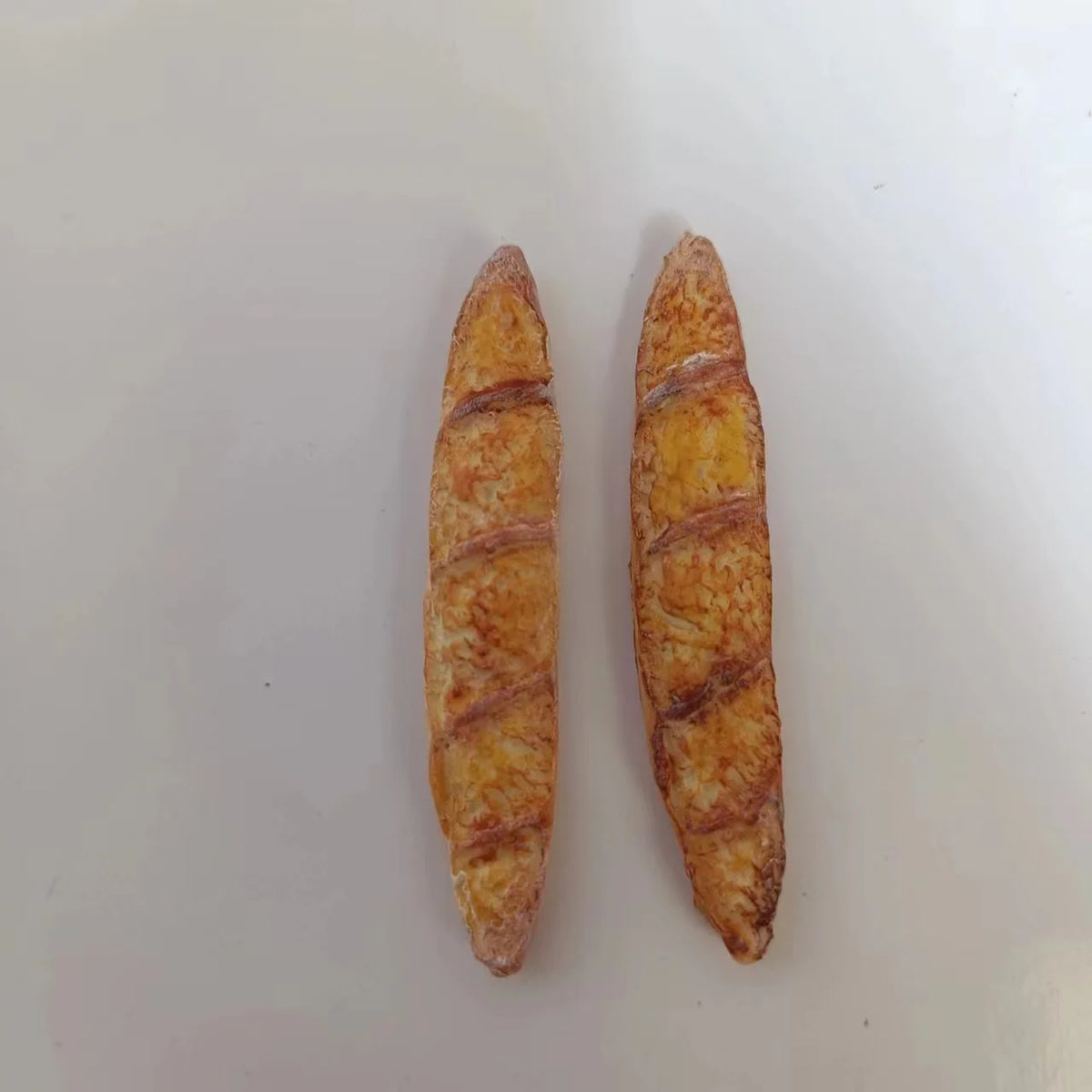 Two miniature baguette loaves used for dollhouse kitchens