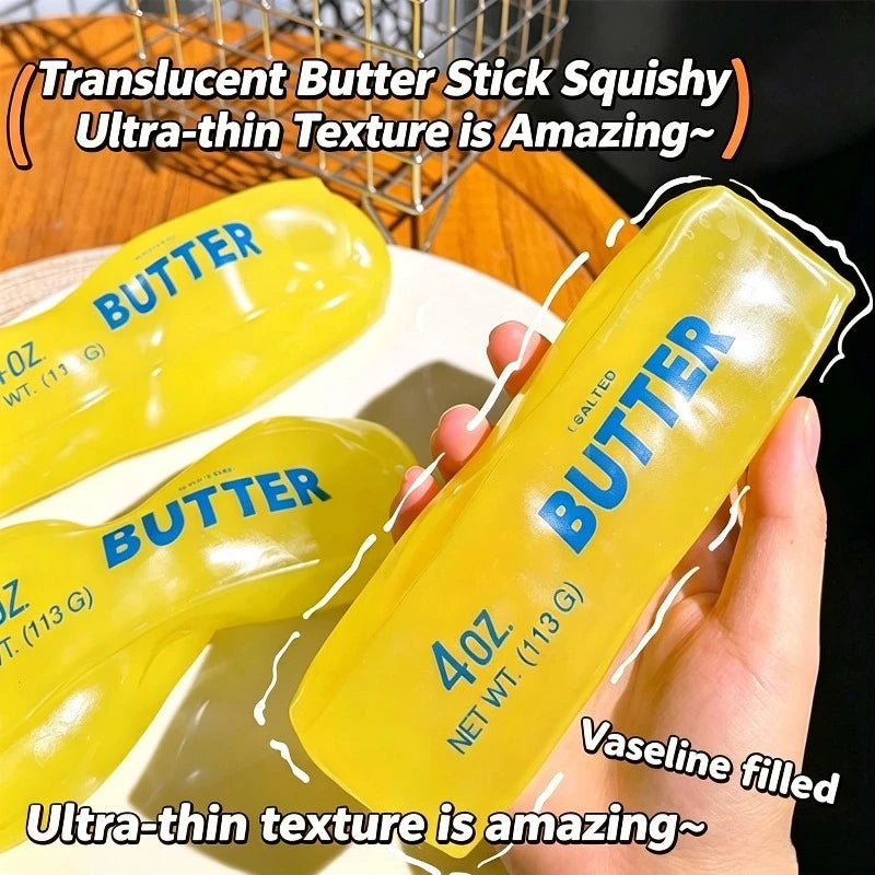 A hand holds a yellow butter stick squishy toy with the text BUTTER on it, demonstrating its ultra-thin texture.