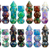 A set of seven polyhedral dice in various colors and glitters arranged in a row.