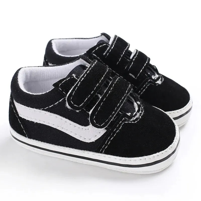 A pair of black and white canvas sneakers with black laces and white soles shown from the side.