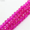 A close-up of pink crystal glass beads arranged in a strand for jewelry making.