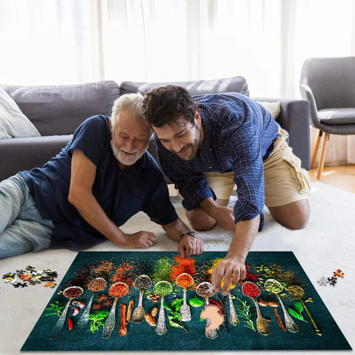 A man and an older man are looking at a colorful jigsaw puzzle spread on a white rug.
