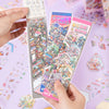 A hand holds a rectangular package of 3D landscape stickers, showing colorful miniature scenes and Japanese text.