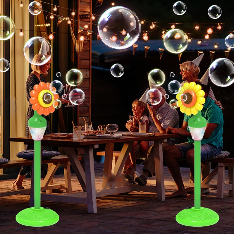 A green automatic sunflower bubble machine is shown on a table with people enjoying bubbles in an outdoor setting.