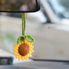 Handmade crochet sunflower charm with green stem hanging from a mirror.