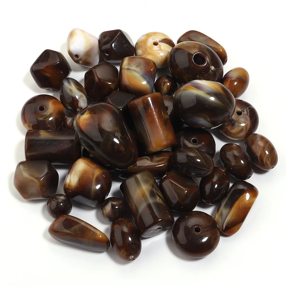 A pile of dark brown and amber colored acrylic beads for jewelry making