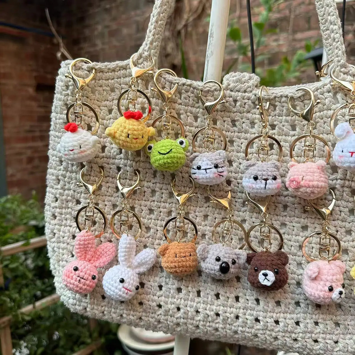 A beige crochet tote bag filled with various animal keychain charms including a rabbit, chick, cat, and dog.