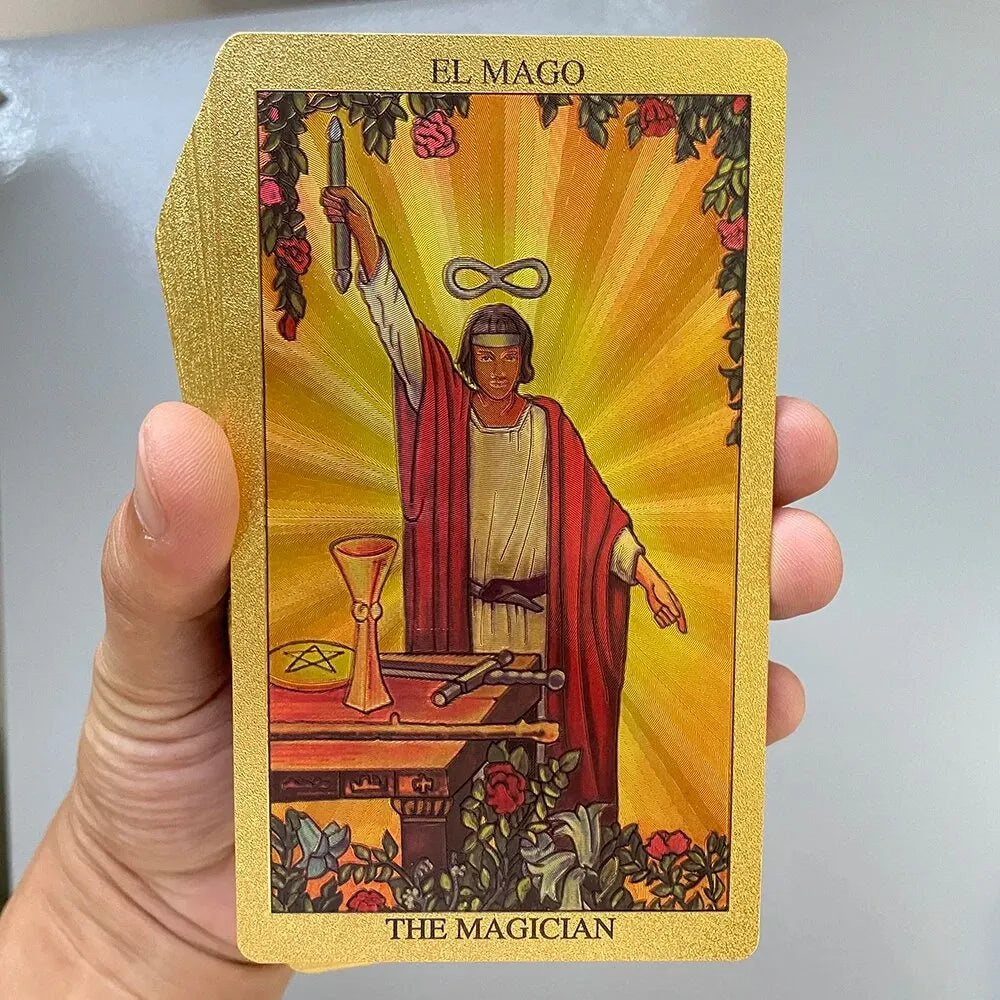 A golden foil tarot card titled El Mago featuring a figure holding a wand and surrounded by light.