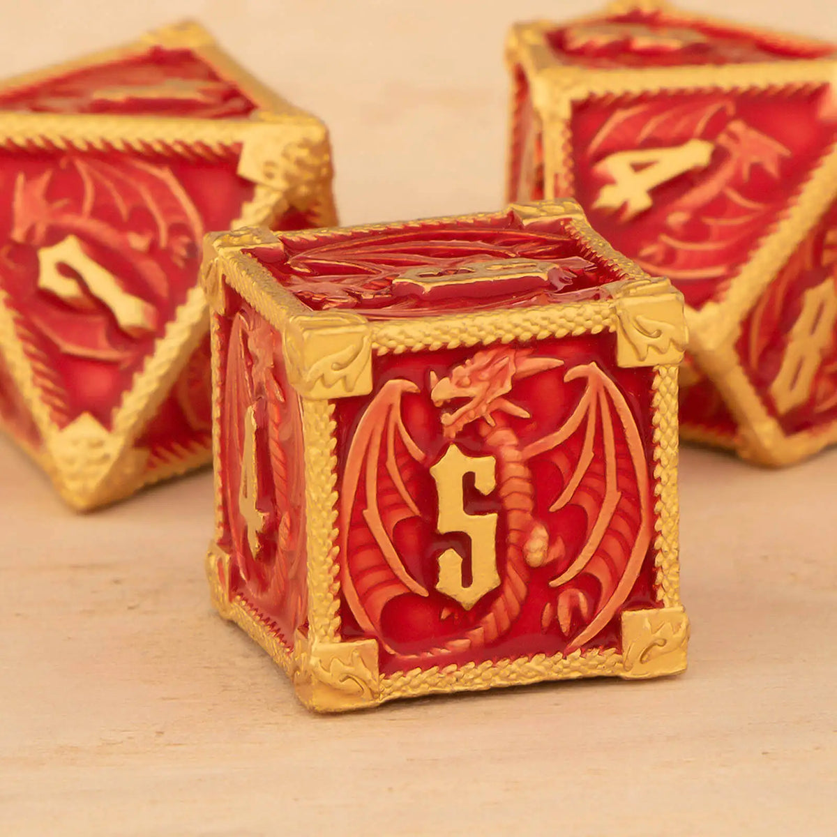 A close-up of a red and gold metal dice set for Dungeons & Dragons, featuring polyhedral dice.