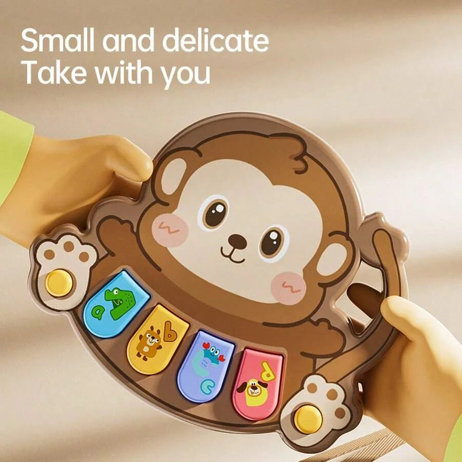 A hand holds a brown bear-shaped musical piano toy for kids with animal figures and lights.