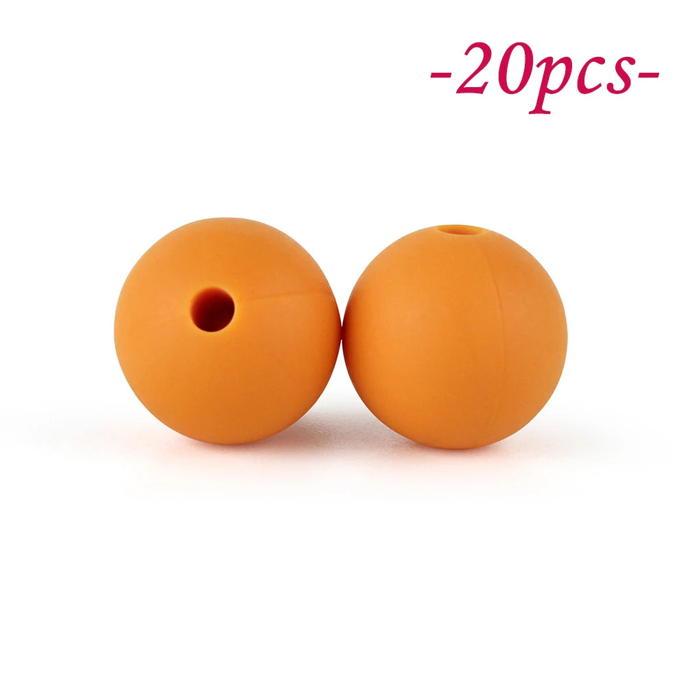 Two round, orange silicone beads are shown against a white background.