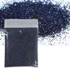 A black bag of holographic fine glitter powder scattered on a white surface.