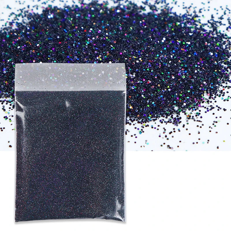 A black bag of holographic fine glitter powder scattered on a white surface.