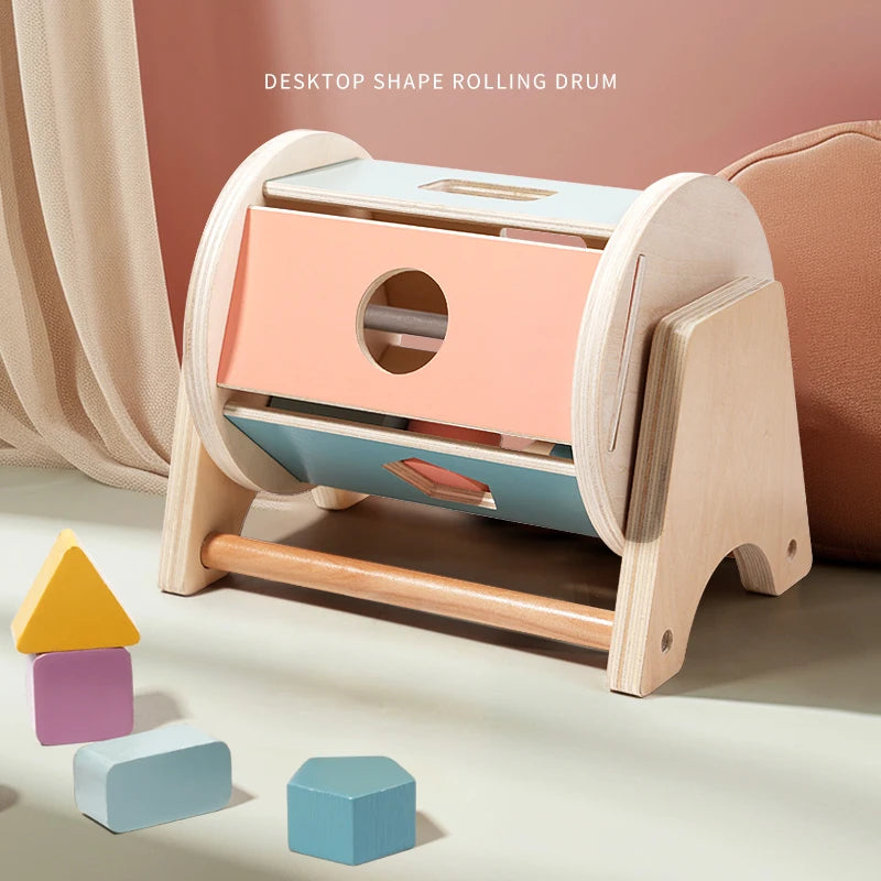 A wooden desktop shape rolling drum with various colored blocks and a wooden handle for sensory play.