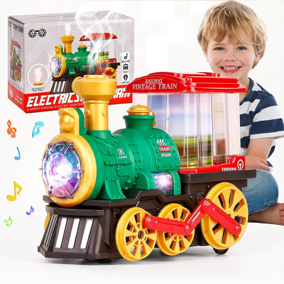 A green electric steam train toy truck with yellow lights and a red engine is shown next to its packaging.