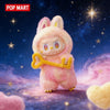 A pink Labubu vinyl plush pendant blind box featuring a rabbit character against a starry, purple and pink background.