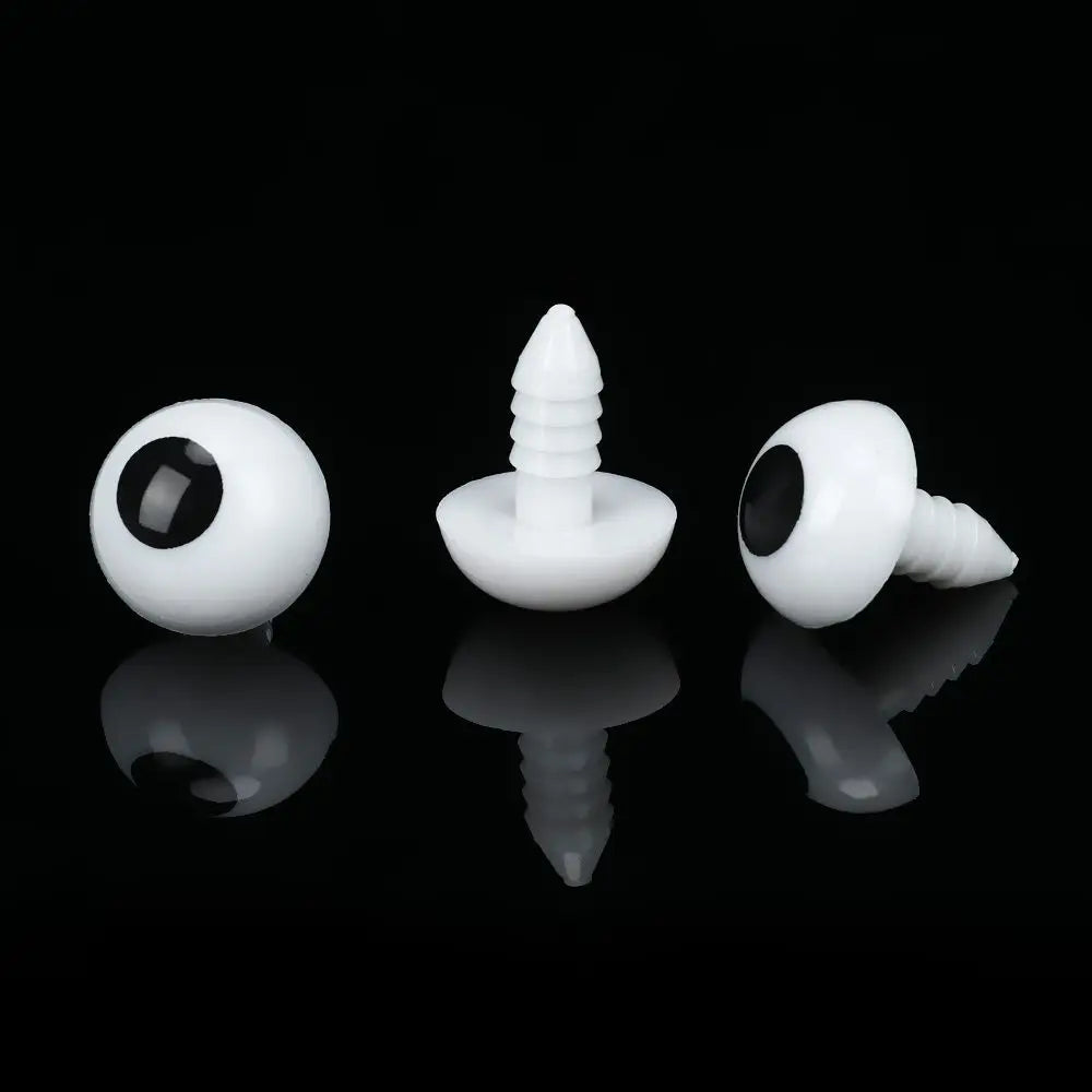 A set of white plastic safety eyes for amigurumi and stuffed animals, shown with reflections on a black surface.