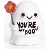 A white crochet ghost doll with a pink flower on its head holding a card that reads You're my boo