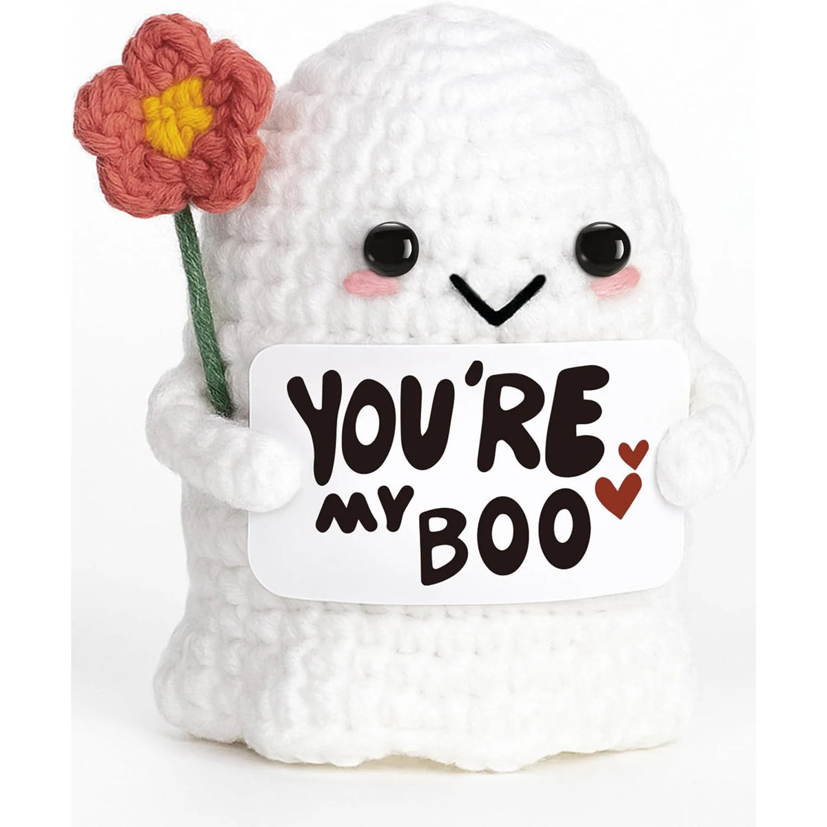 A white crochet ghost doll with a pink flower on its head holding a card that reads You're my boo