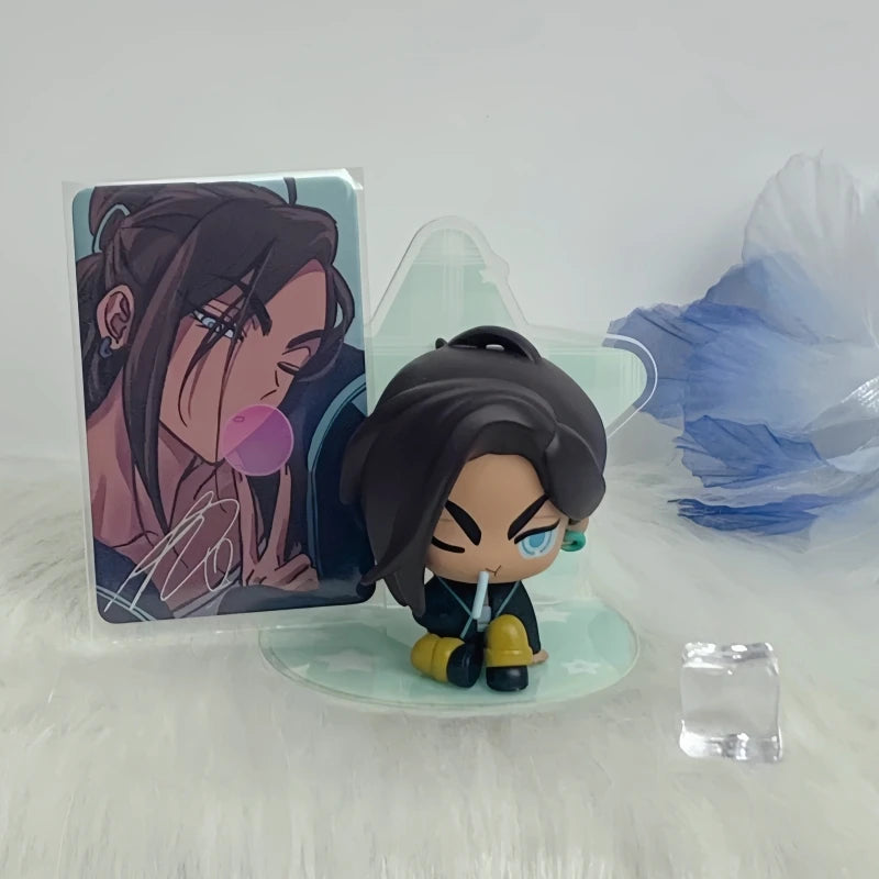 A blind box figure of a dark-haired character in a pink outfit is displayed next to its packaging and blue plastic accessorie
