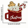 A festive cartoon character iron-on patch depicting a red mug filled with whipped cream and a striped marshmallow topping.