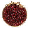 A pile of deep red glass crackle beads for jewelry making, tied with a gold ribbon.