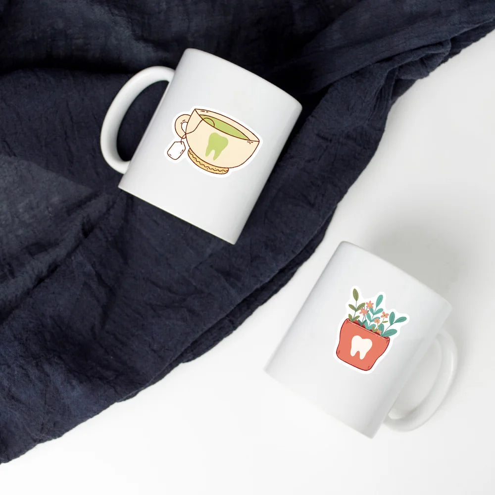 A white mug featuring a decorative illustration of a tooth inside a bowl, set against a dark blue fabric background.